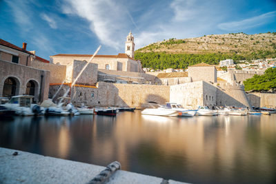 Buildings by lake against sky