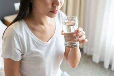 Midsection of woman drinking glass