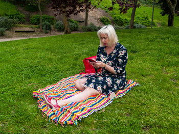 Woman sitting on grassy field
