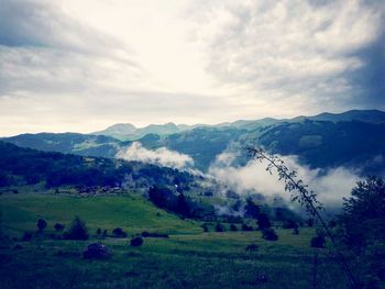 Scenic view of field and mountains against sky