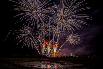 Huge, colorful fireworks over the rice fields at dusk.