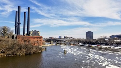 River amidst buildings in city against sky