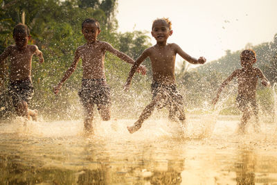Happy boys splashing water in lake