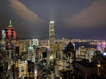 Illuminated buildings in city against sky at night