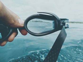 Cropped hand holding swimming goggles