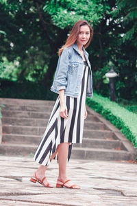 Portrait of woman standing against wall