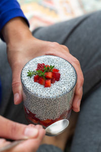 Vegan healthy eating and dieting food concept. female hands holding chia pudding with strawberries