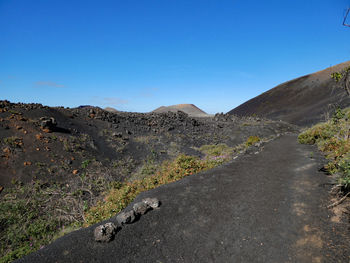 Scenic view of volcanic mountains against clear blue sky