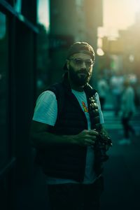 Young man wearing sunglasses standing on street in city