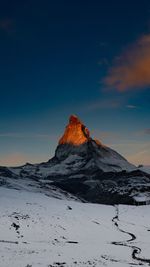 Scenic view of snowcapped mountains against sky during sunset