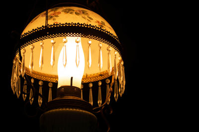 Low angle view of illuminated lamp in darkroom