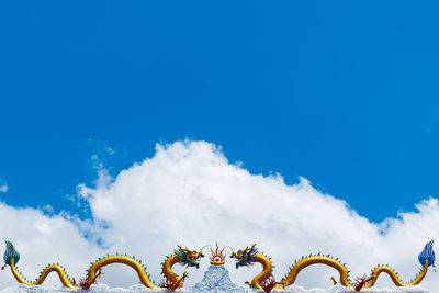 Low angle view of dragons against blue sky