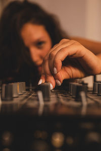 Close-up of fashionable young woman playing music at home