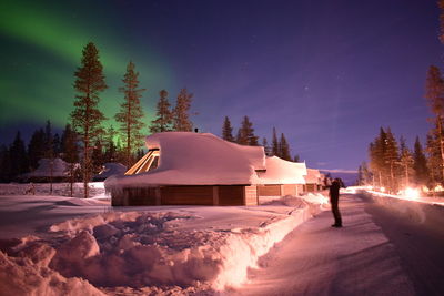 Digital composite image of building and trees against sky at night