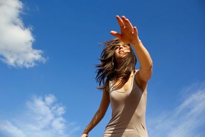 Low angle view of woman against blue sky