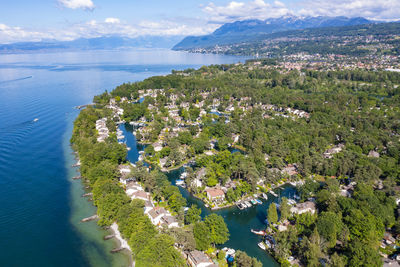 High angle view of townscape by sea against sky