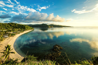 Magnificent view overlooking a beach with the clear, calm sea reflecting the early morning sky.