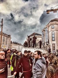 People on street against buildings in city