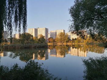 Reflection of trees and buildings in lake against sky