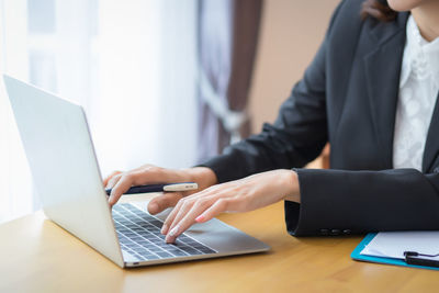 Midsection of man using laptop on table