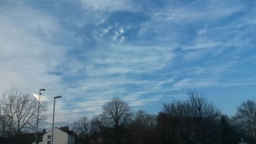 Low angle view of bare tree against cloudy sky