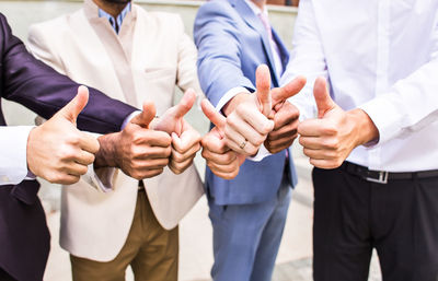 Midsection of business people stacking hands