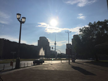 Sun shining through clouds over city