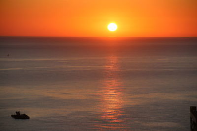 Scenic view of sea against orange sky