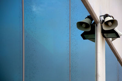 Low angle view of lamp against blue wall