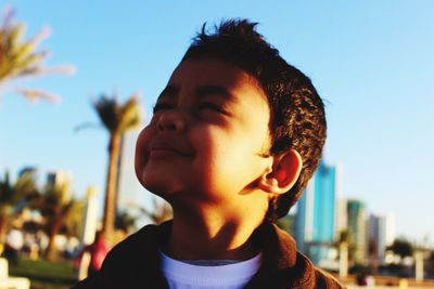 Portrait of boy looking away against clear sky