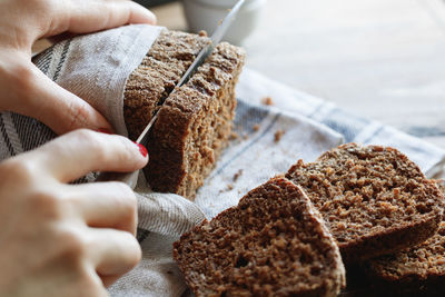 Close-up of woman cutting slices of cake