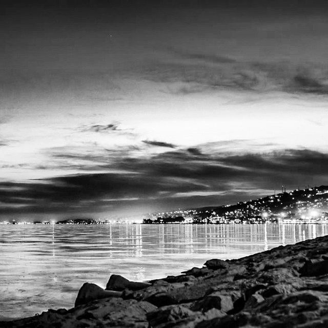 water, sea, sky, beach, shore, built structure, scenics, cloud - sky, pier, horizon over water, tranquil scene, rock - object, tranquility, beauty in nature, building exterior, architecture, nature, reflection, dusk, illuminated