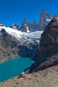 Scenic view of snowcapped mountains against blue sky