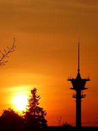 Low angle view of silhouette tree against orange sky