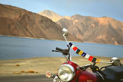 Close-up of motorcycle on road against mountain range