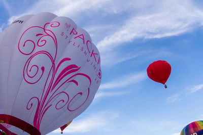 Low angle view of balloons flying against sky