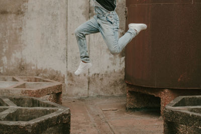 Low section of person jumping against wall
