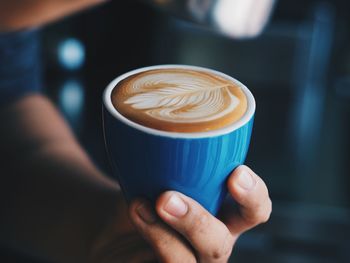 Close-up of hand holding coffee cup