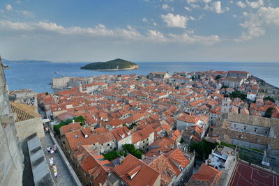 High angle view of townscape by sea against sky