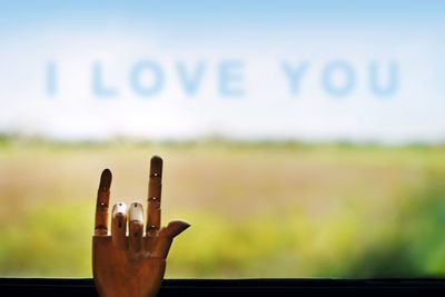 Close-up of hand against window