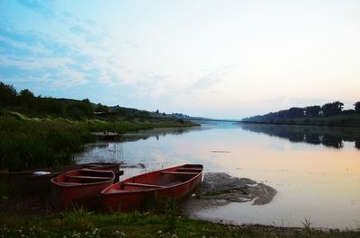 Boats moored in lake against sky
