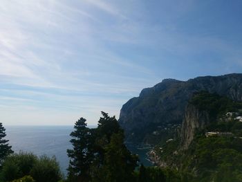 Scenic view of sea and mountains against sky