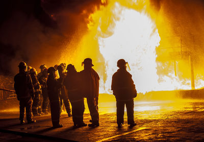 Silhouette men on fire during sunset