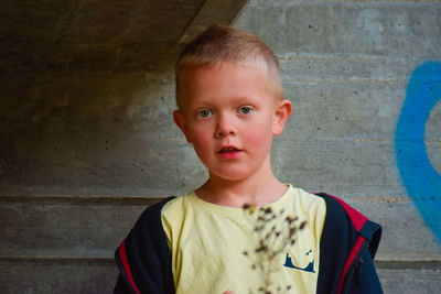 Portrait of cute boy against wall