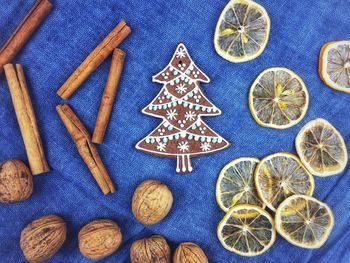 High angle view of gingerbread cookies with lemon and walnuts by cinnamon on table