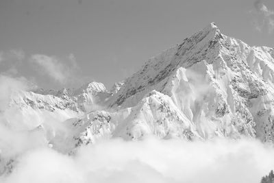 Low angle view of snowcapped mountains against sky