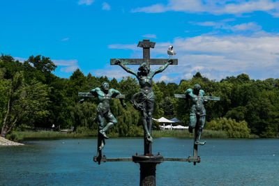Statue against trees and blue sky