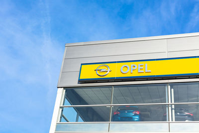 Low angle view of information sign against blue sky