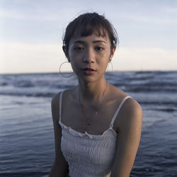 Portrait of young woman standing on beach