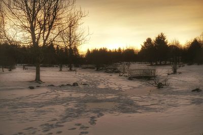 Snow covered field at sunset